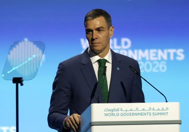 İspanya Başbakanı Pedro Sanchez, Dubai'deki konferansta kürsüde konuşuyor, üzerinde koyu renk bir takım elbise var